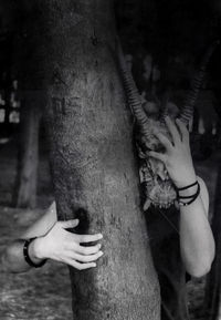 Close-up of hands holding tree trunk