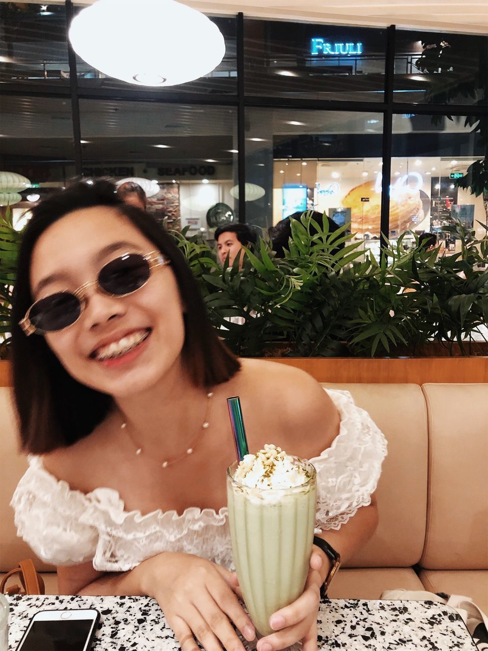 PORTRAIT OF A SMILING YOUNG WOMAN WITH DRINK