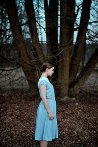 Side view of young woman standing on field