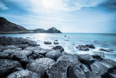 Rocks in sea against sky