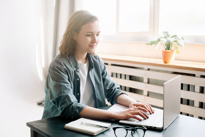 Young woman using laptop at home