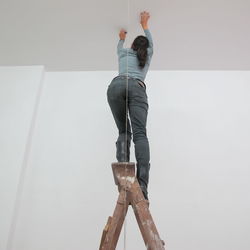 Low angle view of woman on ladder