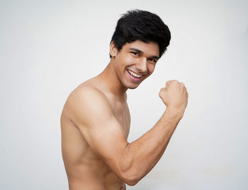 Portrait of smiling young man against white background