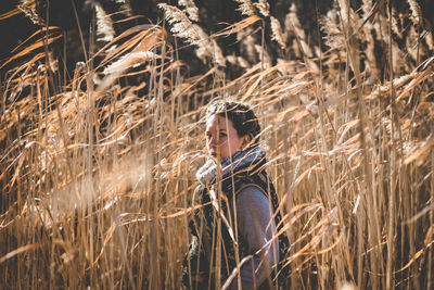 Portrait of young woman standing in wheat field