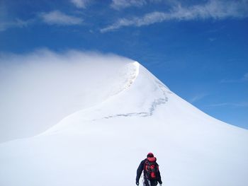 Man on mountain against sky during winter