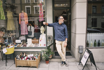 Confident owner standing against store looking away