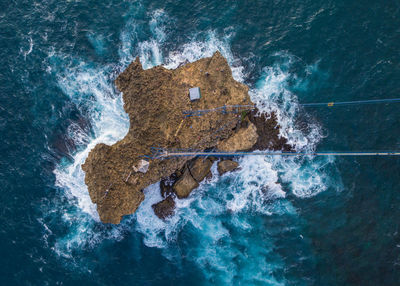 Aerial view of waves splashing on rocks