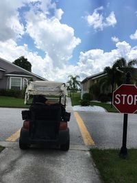 Cars on road by building against sky