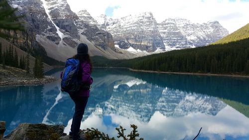 Rear view of woman standing on the edge of lake louise