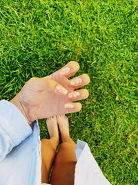 Low section of woman showing nail art while standing on land