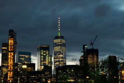 Illuminated buildings in city against sky at night