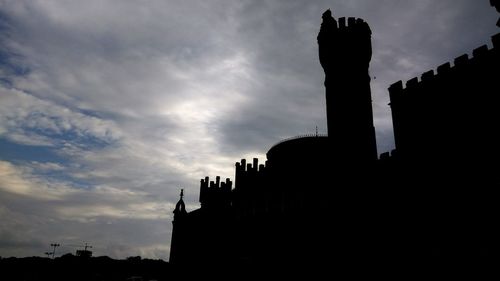 Low angle view of silhouette temple against cloudy sky