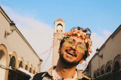 Portrait of young man smiling behind old clock tower in orange flower festival adana turkey