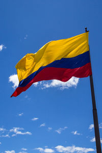 Low angle view of flag against blue sky