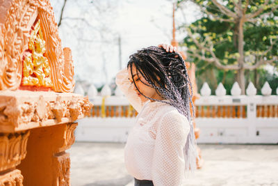 Side view of young woman looking at camera