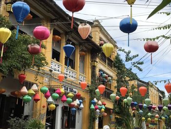 Low angle view of lanterns hanging amidst buildings in city