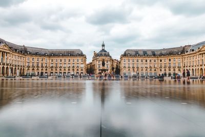 Buildings in city against cloudy sky