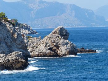 Scenic view of rocks in sea against sky