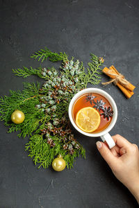 Cropped hand of person holding tea cup on table