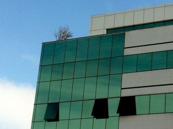 Low angle view of modern building against blue sky