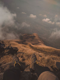 Low section of person on mountain against sky