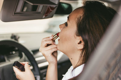 Portrait of woman holding smart phone in car