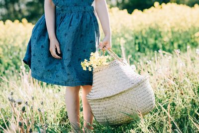 Young girls hands holding a flower basket outside in summer