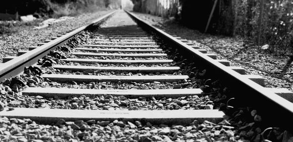 Diminishing perspective of railroad track during sunny day