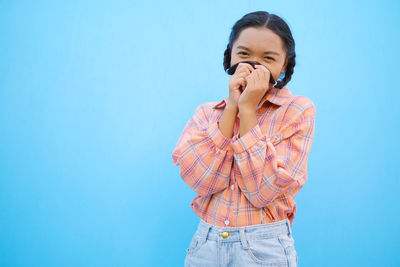 Woman standing against blue background