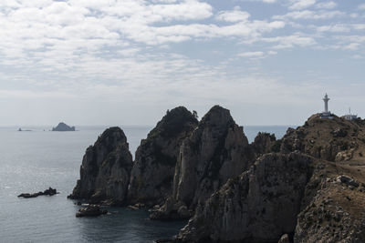 Rock formations in sea against sky