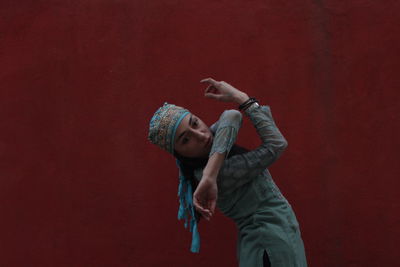 Woman dancing against wall