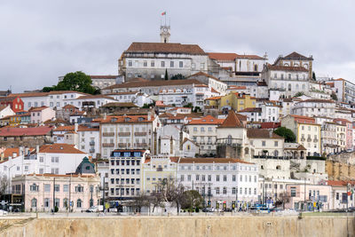 Portuguese city with white buildings and red-tiled roofs on a hill. coimbra cityscape