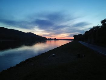 Scenic view of lake against sky at sunset