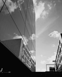 Low angle view of modern building against cloudy sky