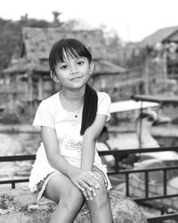 Portrait of smiling girl sitting outdoors