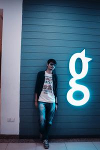 Full length of teenage girl standing against wall