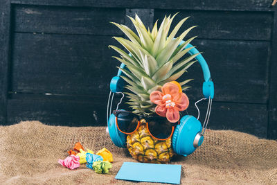 High angle view of sunglasses and headphones over pineapple on table