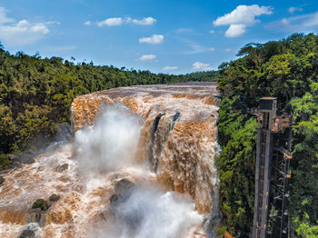 Scenic view of waterfall against sky