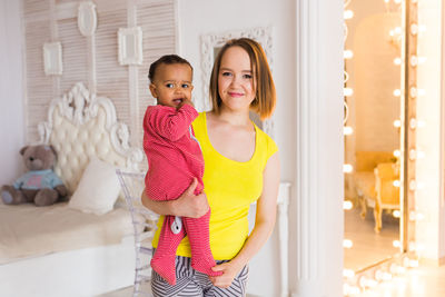 Portrait of smiling young woman standing at home