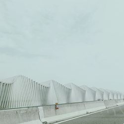 Bridge over road against sky in city