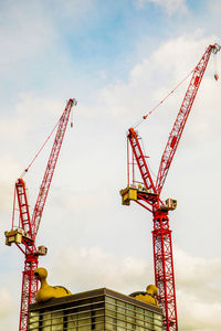 Low angle view of crane against sky