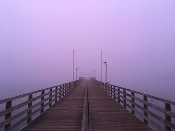 Empty footbridge against clear sky