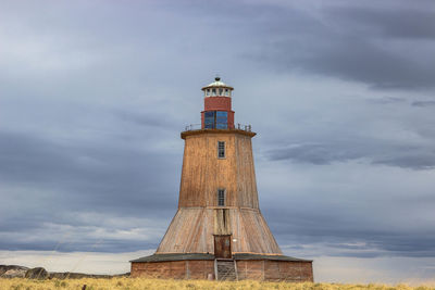 Lighthouse by sea against sky