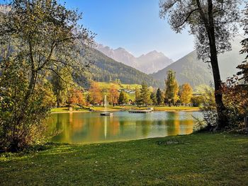 Scenic view of lake by trees against sky