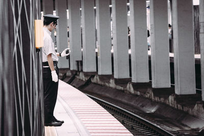 Side view of woman standing on railroad track