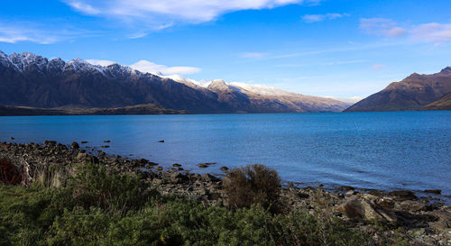 Scenic view of sea and mountains against sky