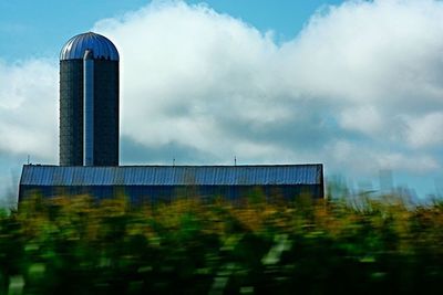 Low angle view of modern building against cloudy sky