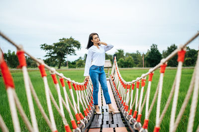 Full length of woman standing on field against sky