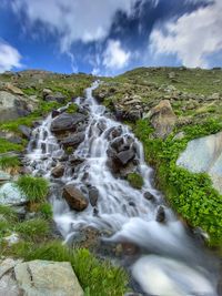 Scenic view of waterfall against sky