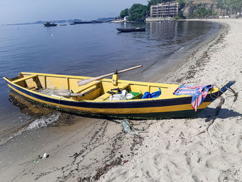 Boats moored on beach against sky